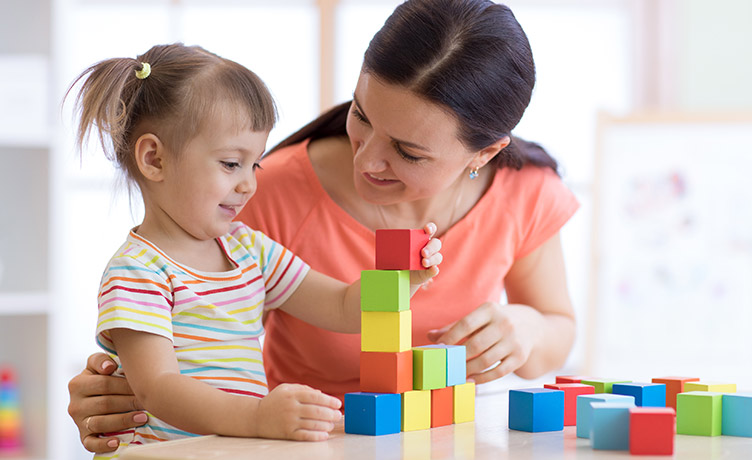 Une assistante maternelle accueille une petite fille